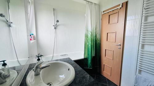 a bathroom with a sink and a toilet and a door at Apartment KLENOT in Vyšné Ružbachy