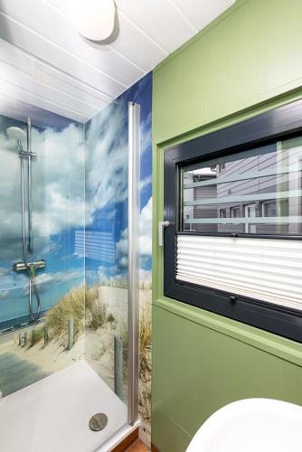 a bathroom with a window with a view of the beach at Schwimmende Häuser im BALTIC SEA RESORT in Kröslin