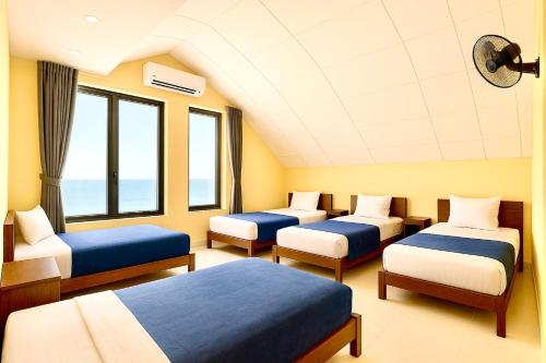a hospital room with four beds and windows at Golden River Hotel in Hoi An