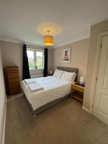 a bedroom with a large bed and a window at Spacious Two Bedroom Apartment in Bracknell in Bracknell