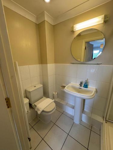 a bathroom with a toilet and a sink and a mirror at Spacious Two Bedroom Apartment in Bracknell in Bracknell