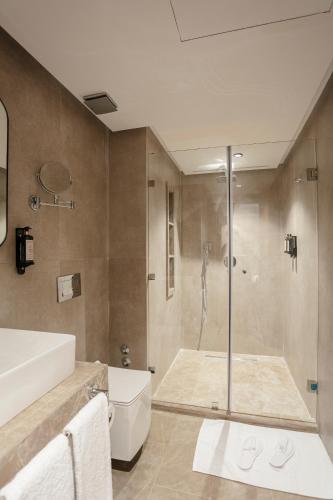a bathroom with a shower and a toilet and a sink at NearYo Hotels in Marrakech