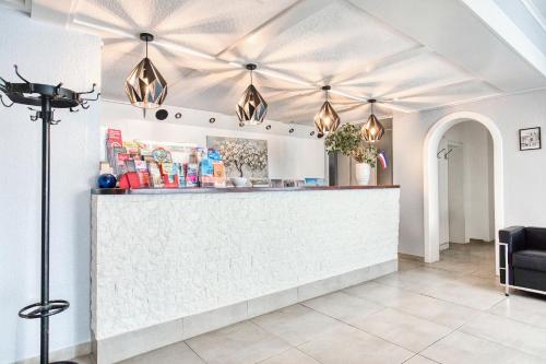 a restaurant with a counter and lights on the ceiling at D&D Hotel by Wiggers in Bad Oldesloe