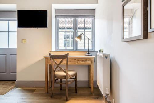 a desk in a room with a chair and a window at Charlcombe Inn in Bath