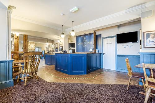 a room with blue cabinets and a table and chairs at Charlcombe Inn in Bath
