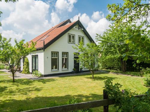 a white house with a red roof at Peaceful Dune Retreat with Garden in Schoorl
