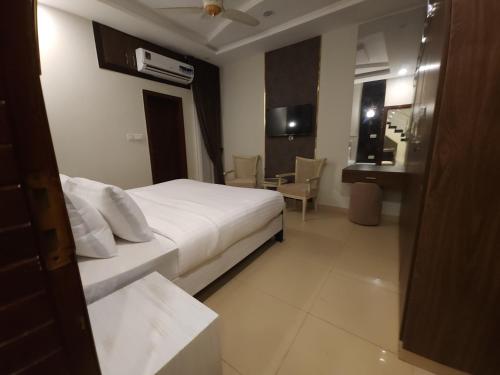 a hotel room with a white bed and a bathroom at Aspire Lodge, G11 Islamabad - A Family Guest House & Hotel in Islamabad