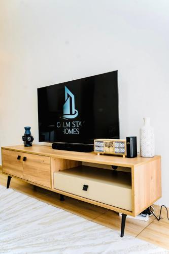 a tv sitting on top of a wooden entertainment center at Cozy Luxe Haven Lakeside Condo in Entebbe in Entebbe