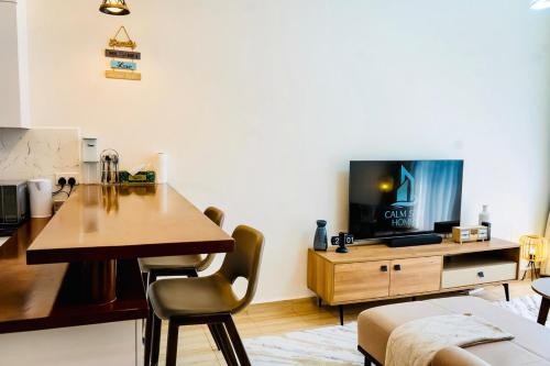 a living room with a wooden table and a television at Cozy Luxe Haven Lakeside Condo in Entebbe in Entebbe