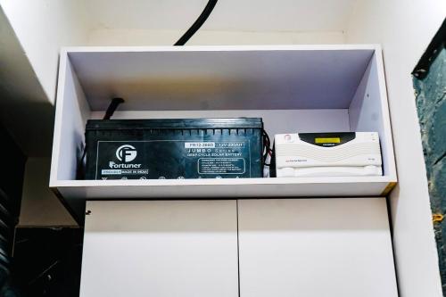 a white cabinet with a box and a battery at Cozy Luxe Haven Lakeside Condo in Entebbe in Entebbe