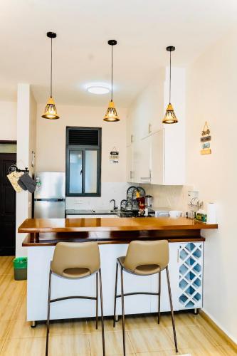 a kitchen with white cabinets and a counter with stools at Cozy Luxe Haven Lakeside Condo in Entebbe in Entebbe