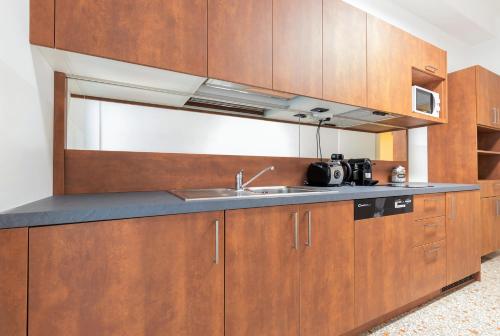 a kitchen with wooden cabinets and a sink at Milan Retreats in Milan