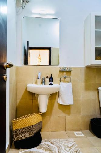 a bathroom with a sink and a mirror at Cozy Luxe Haven Lakeside Condo in Entebbe in Entebbe