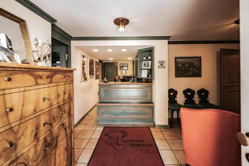 a bar in a kitchen with a counter and orange chairs at Landhotel Hirsch in Tübingen