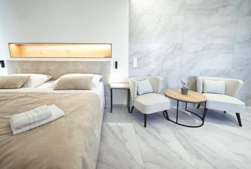 a bedroom with two beds and a table and chairs at Enotéka Vinofol - winebar & café & apartments in Mikulov
