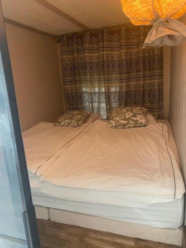 a small bed with two pillows in a room at Cheerful house with sauna and bathtub in Almunge
