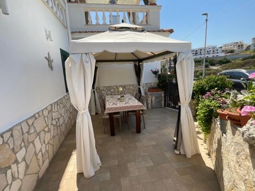 a gazebo with a table under it on a patio at Casa Sundaville in Peschici