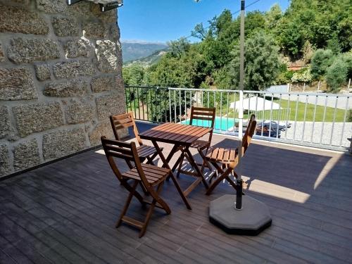 a wooden table and chairs on a deck at Várzeas Nature House in Soengas