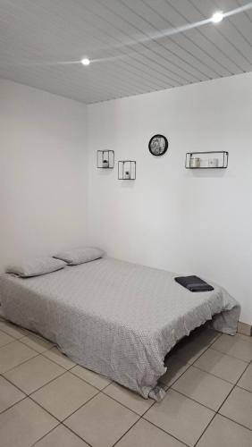 ein weißes Schlafzimmer mit einem Bett in einer weißen Wand in der Unterkunft Logement au calme, avec vue dégagée in Ardoix