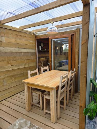 a wooden table and chairs on a wooden deck at Miss Francis Horse Wagon in Looe