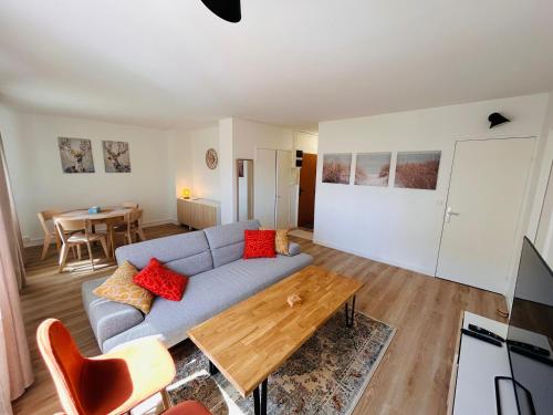 a living room with a couch and a table at Le Millésime Florence Stationnement in Reims