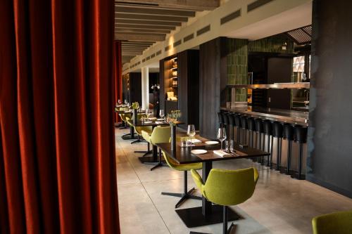 a restaurant with a row of tables and yellow chairs at I Vivai in Montemurlo