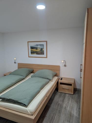 a bedroom with two beds and a night stand at Gästehaus Arracher Hof in Arrach