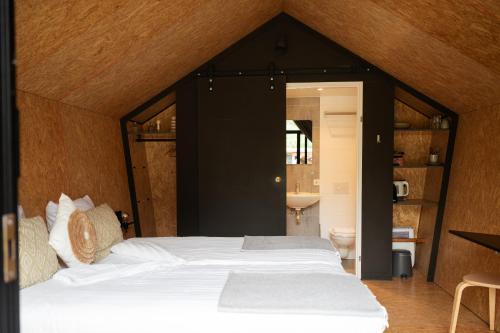 a bedroom with a large bed in a room at Tenthuisje in het groen, een suite met eigen badkamer in Callantsoog