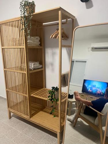 a person sitting in a chair in front of a desk with a computer at Beautiful studio on Tel Aviv beach in Tel Aviv
