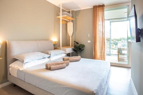 ein Schlafzimmer mit einem großen Bett mit zwei Kissen darauf in der Unterkunft Jesolo Vista Lido - Rooftop Suite in Lido di Jesolo