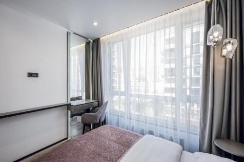Una habitación de hotel con una cama y una ventana. en Petrovdom Apartments 5-123, Building 18, in RC Fayna Town, Saliutna Street 2, en Kiev