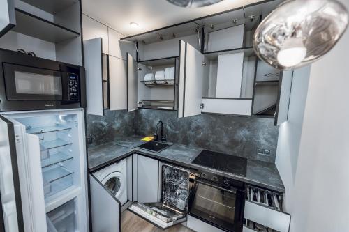 Una cocina con gabinetes blancos y un horno de estufa. en Petrovdom Apartments 5-123, Building 18, in RC Fayna Town, Saliutna Street 2, en Kiev