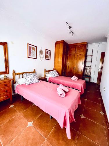 two beds in a room with pink sheets at Costa Suri Casa in Nerja