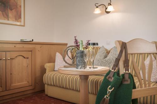 a living room with a couch and a table with a green bag at Biohotel Rastbichlhof in Neustift im Stubaital