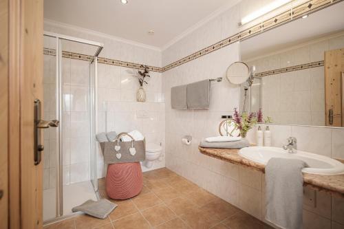 a bathroom with a shower and a sink and a toilet at Biohotel Rastbichlhof in Neustift im Stubaital