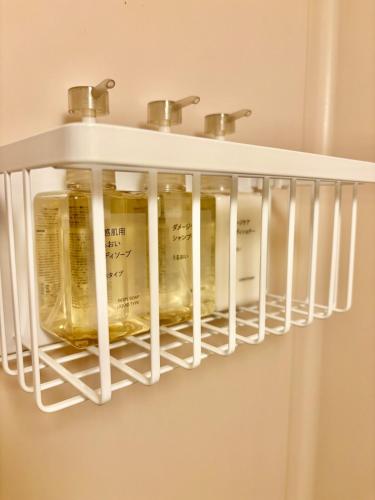 a shelf in a bathroom with bottles of wine at Hachioji House 206 Apartment in Hachioji