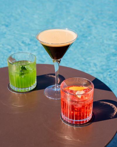 two cocktails sitting on a table next to a pool at I Vivai in Montemurlo