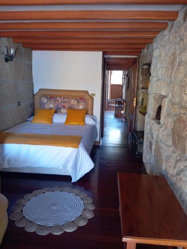 Un dormitorio con una cama y una pared de piedra. en Casa da laxe, en Combarro
