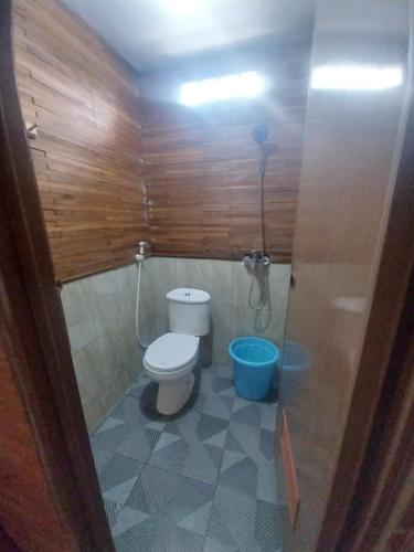a bathroom with a toilet and a blue bucket at Varvara hill in Cigugur