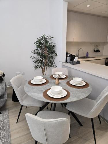 a kitchen with a table with chairs and a tableasteryasteryasteryasteryasteryastery at 2bhk Canal View near Ferrari World and Sea World in Abu Dhabi