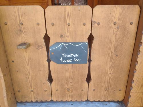a wooden fence with a sign that reads mountain village farm at Mountain Village Room in Habkern