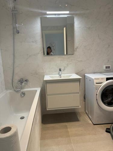 a bathroom with a sink and a washing machine at Pipera Platza Residence 5 luxury 1 bedroom in Voluntari