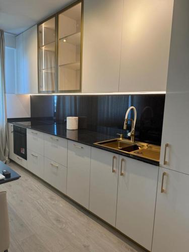 a kitchen with white cabinets and a sink at Pipera Platza Residence 5 luxury 1 bedroom in Voluntari