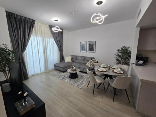 a living room with a couch and a table and chairs at 2bhk Canal View near Ferrari World and Sea World in Abu Dhabi