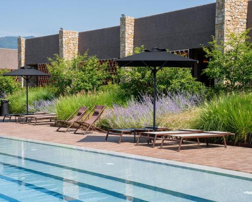 a pool with tables and umbrellas next to a building at I Vivai in Montemurlo