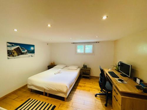 a bedroom with a bed and a desk with a computer at Côté Nature in Sciez