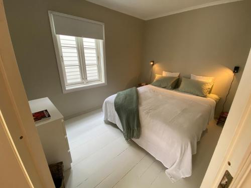 a bedroom with a white bed and a window at A cosy flat in the heart of Stavanger in Stavanger