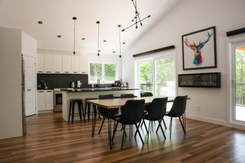 Spa and Lakefront - Oasis des chutes في Lac-Saint-Paul: مطبخ وغرفة طعام مع طاولة وكراسي
