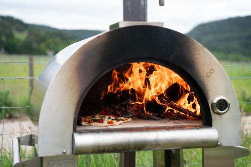 a pizza is being cooked in a pizza oven at Ailsa- Enchanting Tiny House with wood burner and hot tub in Cairngorms in Ballater