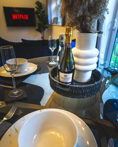 a table with a bottle of wine and plates and glasses at The Cove in Solihull